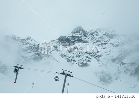 Ski resort showcases sweeping snow-covered mountains with gondolas suspended Ski resort showcases sweeping snow-covered mountains with gondolas suspended 141713310