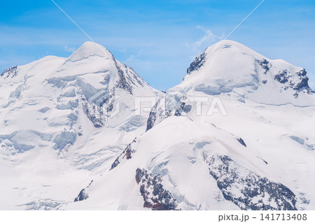 Snow Capped Mountains and Glacier near Matterhorn Mountain in Zermatt, Switzerland, Scenic Swiss Alps Landscape under Blue Sky, Famous Swiss Alps Landmark and popular European Travel Destination Snow Capped Mountains and Glacier near Matterhorn Mountain in Zermatt, Switzerland, Scenic Swiss Alps Landscape under Blue Sky, Famous Swiss Alps Landmark and popular European Travel Destination 141713408