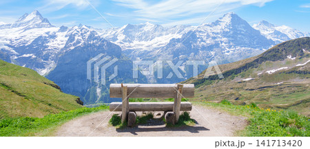 Scenic view of Swiss Alps with bench for taking view at Grindelwald First, Switzerland. Beautiful landscape in Jungfrau Region. famous Europe summer hiking trail and travel destination Scenic view of Swiss Alps with bench for taking view at Grindelwald First, Switzerland. Beautiful landscape in Jungfrau Region. famous Europe summer hiking trail and travel destination 141713420