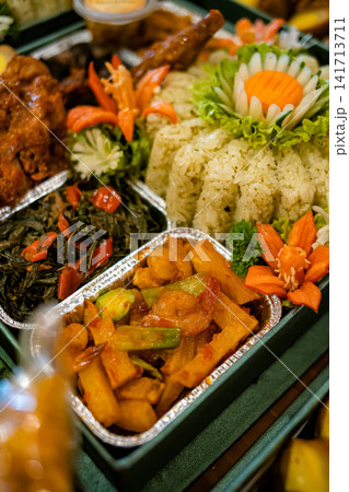 Macro detail of Indonesian kaffir lime rice served with sambal vegetables and chicken in catering box. Authentic traditional food with rich colors and texture. Macro detail of Indonesian kaffir lime rice served with sambal vegetables and chicken in catering box. Authentic traditional food with rich colors and texture. 141713711