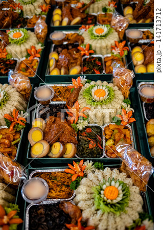 Indonesian boxed meals featuring rice, eggs, vegetables, and traditional side dishes. Suitable for catering, food service, and Southeast Asian cuisine themes. Indonesian boxed meals featuring rice, eggs, vegetables, and traditional side dishes. Suitable for catering, food service, and Southeast Asian cuisine themes. 141713712
