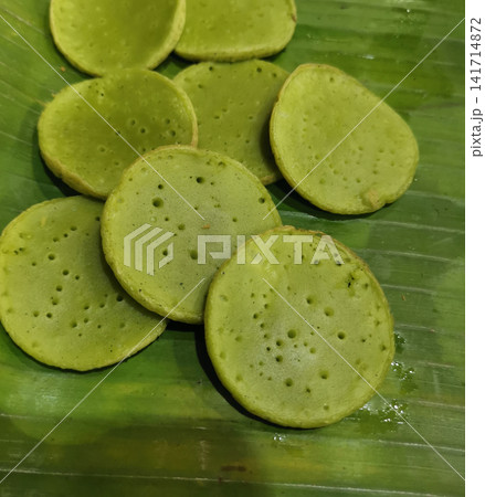 Traditional Indonesian pandan rice pancakes arranged on banana leaf. Authentic Southeast Asian dessert suitable for food, travel, restaurant, hospitality, and cultural projects. Traditional Indonesian pandan rice pancakes arranged on banana leaf. Authentic Southeast Asian dessert suitable for food, travel, restaurant, hospitality, and cultural projects. 141714872
