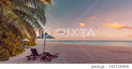 Romantic beach loungers under palm-fringed umbrella at pastel sunset on powder-white sand tropical shore. Perfect summer vacation travel landscape paradise. Luxury honeymoon getaway relax scenic Romantic beach loungers under palm-fringed umbrella at pastel sunset on powder-white sand tropical shore. Perfect summer vacation travel landscape paradise. Luxury honeymoon getaway relax scenic 141716409