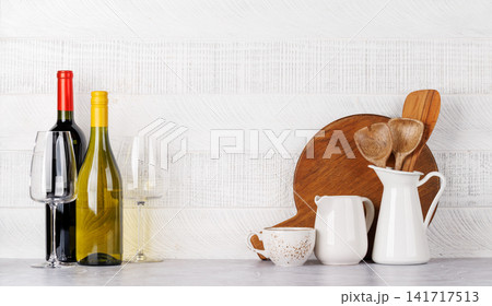Kitchen utensils and wine bottles on table Kitchen utensils and wine bottles on table 141717513