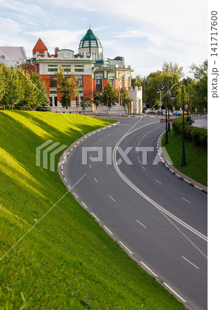 Curved empty road beside green park slope in Samara, Russia. Curved empty road beside green park slope in Samara, Russia. 141717600