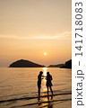 夕日の海で寄り添うカップル 141718083