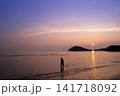 夕焼けに染まる海岸線と子ども 141718092