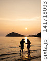 夕日の海で寄り添うカップル 141718093