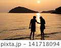 夕日の海で寄り添うカップル 141718094