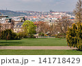 Panoramic Prague cityscape from a peaceful green park with Prague Castle and historic red rooftops in the distance, capturing scenic spring beauty of Prague City Czech Republic 141718429