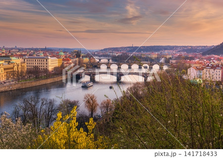Panoramic Prague cityscape with Vltava River and historic bridges at sunset, showcasing colorful spring scenery, European architecture and the romantic skyline of Prague City Czech Republic 141718433