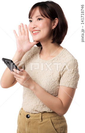 Asian woman waving while holding smartphone with cheerful expression isolated transparent background for friendly 141718746