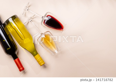 Wine glasses with red and white wine lying on beige background Wine glasses with red and white wine lying on beige background 141718782