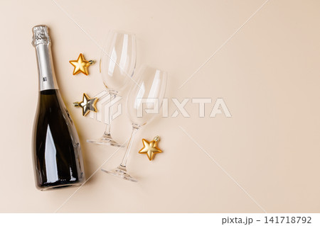 Champagne bottle and glasses on beige background Champagne bottle and glasses on beige background 141718792