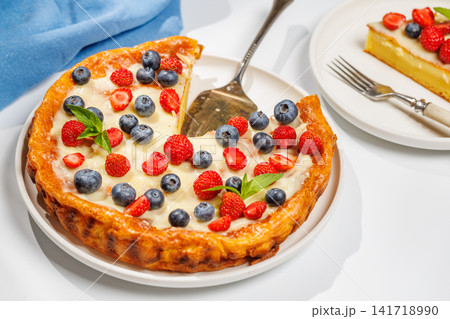 Whole berry tart with missing slice on white background 141718990
