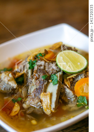 Sop buntut Indonesian oxtail soup with clear broth, vegetables and lime garnish. Traditional Southeast Asian cuisine Sop buntut Indonesian oxtail soup with clear broth, vegetables and lime garnish. Traditional Southeast Asian cuisine 141720335
