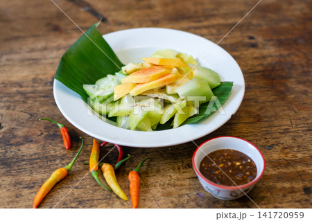 Rujak fruit salad with fresh tropical fruits, chili, and palm sugar sauce. Traditional Indonesian dish, healthy and refreshing Asian cuisine. Rujak fruit salad with fresh tropical fruits, chili, and palm sugar sauce. Traditional Indonesian dish, healthy and refreshing Asian cuisine. 141720959