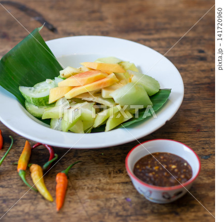 Rujak fruit salad with fresh tropical fruits, chili, and palm sugar sauce. Traditional Indonesian dish, healthy and refreshing Asian cuisine. Rujak fruit salad with fresh tropical fruits, chili, and palm sugar sauce. Traditional Indonesian dish, healthy and refreshing Asian cuisine. 141720960