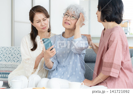 リビングでスマホを見るミドルの女性の友達 リビングでスマホを見るミドルの女性の友達 141721092
