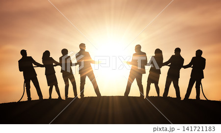 Rival business professionals actively pulling heavy rope opposite directions across outdoor dirt hilltop directly facing bright glowing evening sun displaying physical contest Rival business professionals actively pulling heavy rope opposite directions across outdoor dirt hilltop directly facing bright glowing evening sun displaying physical contest 141721183