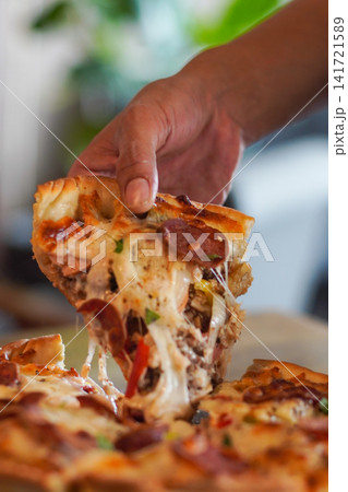 Hot pepperoni pizza slice with melted cheese stretch being lifted. Perfect for restaurant, delivery, and comfort food imagery. Hot pepperoni pizza slice with melted cheese stretch being lifted. Perfect for restaurant, delivery, and comfort food imagery. 141721589