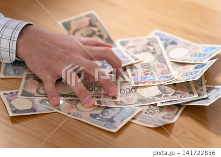 お金を掴む手元 お金を掴む手元 141722856