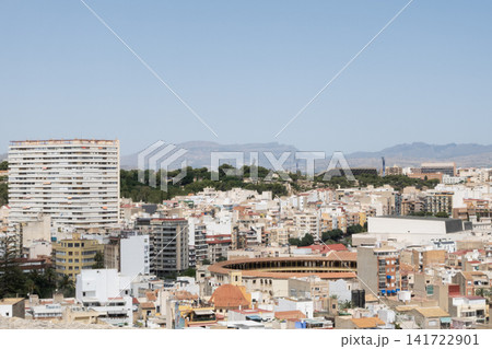 A cityscape view of Alicante, Spain, showcasing dense architecture and mountains in the background 141722901