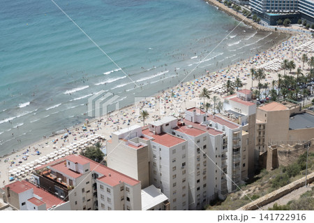 View of Postiguet beach with people, waves and buildings in Alicante View of Postiguet beach with people, waves and buildings in Alicante 141722916
