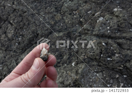 Hand holding a small calcite mineral fragment Hand holding a small calcite mineral fragment 141722933