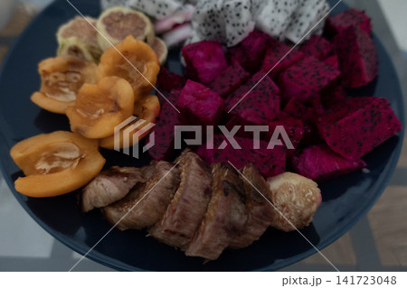 Plate of assorted sliced exotic fruits including red and white dragon fruit, fresh figs and loquats Plate of assorted sliced exotic fruits including red and white dragon fruit, fresh figs and loquats 141723048