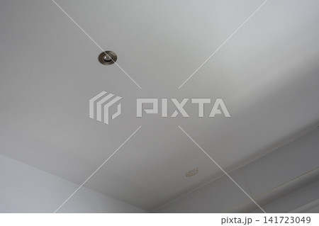 Brown water stain on a white kitchen ceiling caused by roof leak and moisture damage 141723049