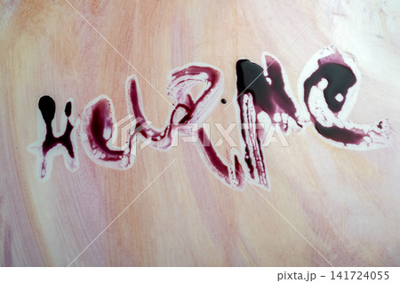 The words HELP ME written in simulated blood on a textured background, representing distress, horror, or a crime scene plea. Concept of Halloween 141724055