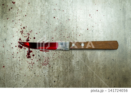 A bloody knife with a wooden handle lies on a concrete floor surrounded by fresh blood splatters, representing a crime scene. Concept of Halloween A bloody knife with a wooden handle lies on a concrete floor surrounded by fresh blood splatters, representing a crime scene. Concept of Halloween 141724056