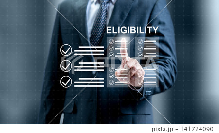 Businessman pointing at a virtual screen with the word 'Eligibility' and checkmark lists, representing compliance, verification, and qualification processes. Concept of Eligibility Businessman pointing at a virtual screen with the word 'Eligibility' and checkmark lists, representing compliance, verification, and qualification processes. Concept of Eligibility 141724090