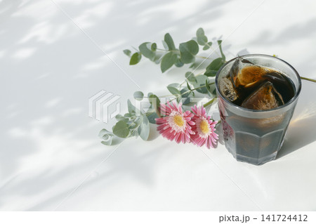 アイスコーヒーとガーベラ、ユーカリが彩る爽やかな夏のカフェイメージ アイスコーヒーとガーベラ、ユーカリが彩る爽やかな夏のカフェイメージ 141724412