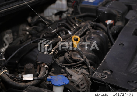 Car engine exposed beneath raised hood for professional servicing. 141724473