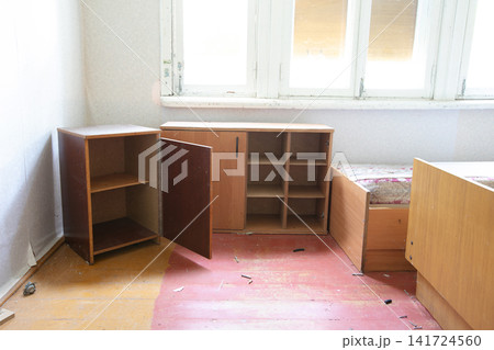Abandoned room with vintage furniture in soft natural light, highlighting warm wooden tones and dusty surfaces Abandoned room with vintage furniture in soft natural light, highlighting warm wooden tones and dusty surfaces 141724560