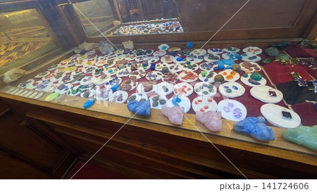Display of colorful natural gemstones and carved animal crystals in wooden glass showcase Display of colorful natural gemstones and carved animal crystals in wooden glass showcase 141724606
