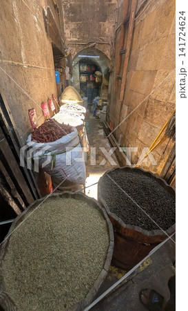 Traditional spice market stall with sacks of herbs in a narrow stone alley 141724624