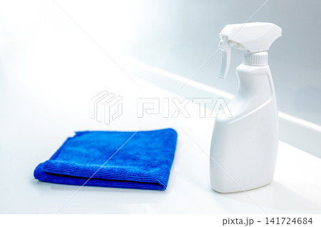 Blue microfiber cloth and detergent spray bottle on modern white countertop in the kitchen Blue microfiber cloth and detergent spray bottle on modern white countertop in the kitchen 141724684