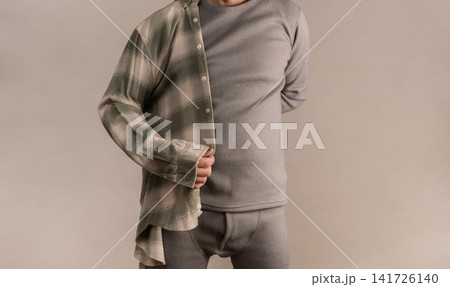 Man wearing thermal wear with open shirt in studio setting. Man wearing thermal wear with open shirt in studio setting. 141726140