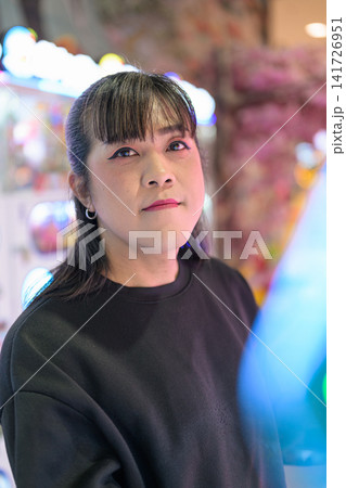 Close-Up Portrait of Asian Woman in Bright Arcade Close-Up Portrait of Asian Woman in Bright Arcade 141726951