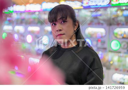 Portrait of Asian Woman Standing near Gashapon Machines Portrait of Asian Woman Standing near Gashapon Machines 141726959