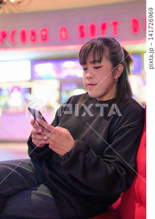 Vertical Close-Up Portrait of Woman Reading Mobile Screen 141726969