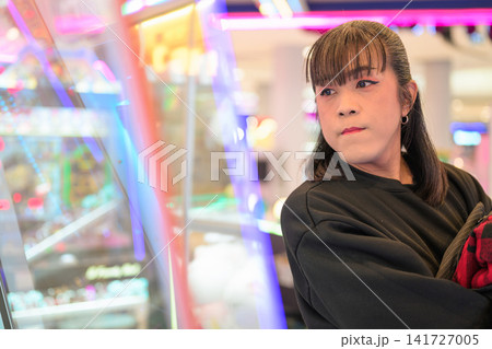 Asian Transgender Woman Looking at Claw Machine Arcade Game Asian Transgender Woman Looking at Claw Machine Arcade Game 141727005