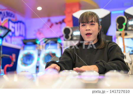 Expressive Woman Thrilled Playing Rhythm Button Game at Arcade Expressive Woman Thrilled Playing Rhythm Button Game at Arcade 141727010