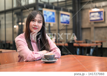 Portrait of a Confident Asian Woman Sitting in a Cafe with a Cup of Coffee 141727060
