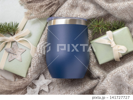 Wine tumbler mockup, blank dark blue stainless steel cup on beige blanket, Christmas rustic scene Wine tumbler mockup, blank dark blue stainless steel cup on beige blanket, Christmas rustic scene 141727727