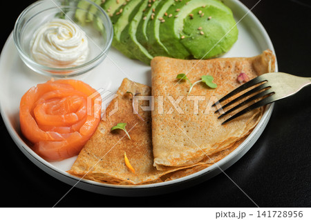 Roasted thin pancakes with smoked salmon and sauce Roasted thin pancakes with smoked salmon and sauce 141728956