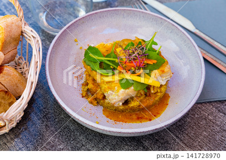 Codfish baked with curry and served with quinoa and greens Codfish baked with curry and served with quinoa and greens 141728970